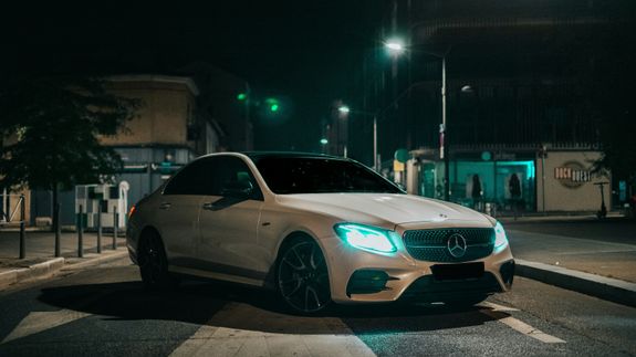 Detailed view of a white car's tail light in a moody outdoor setting.