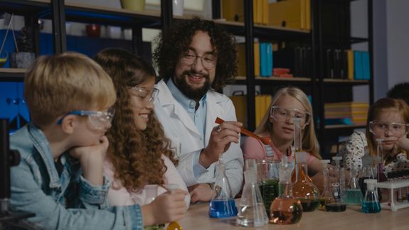 Empty light classroom with blackboard and desks