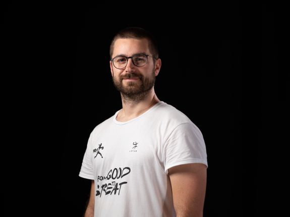 Woman in White Long Sleeve Shirt and Blue Denim Jeans Sitting on Table