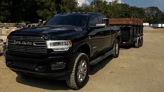 An urban scene depicting overflowing bins and garbage in a parking lot, indicating waste management issues.