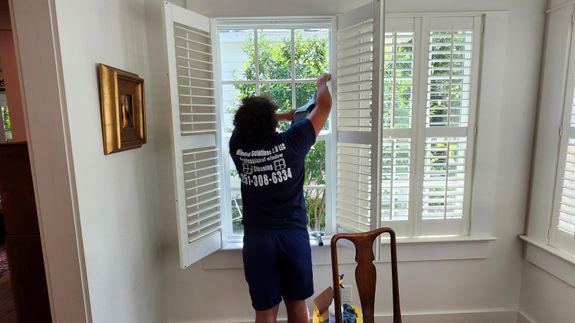 A Person Cleaning Windows of a Building Hanging on a Rope