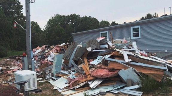 A dimly lit room containing a plastic bag filled with trash, emphasizing waste and recycling.