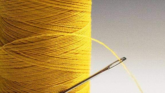 Bald businessman in glasses talks on phone, smiling at office with charts.