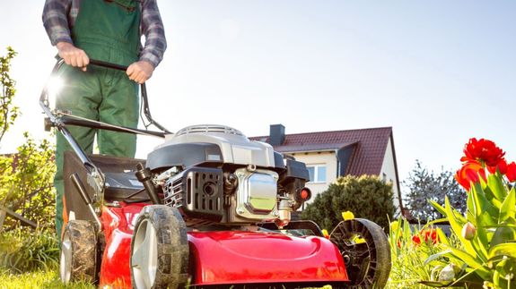 Crop unrecognizable coworkers in formal wear standing at table with laptop and documents while greeting each other before meeting