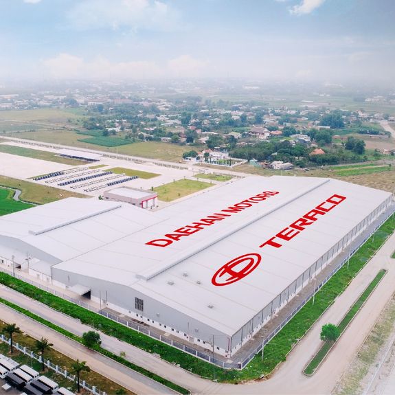 Worker applying a car wrap using a heat gun for precise adhesion.