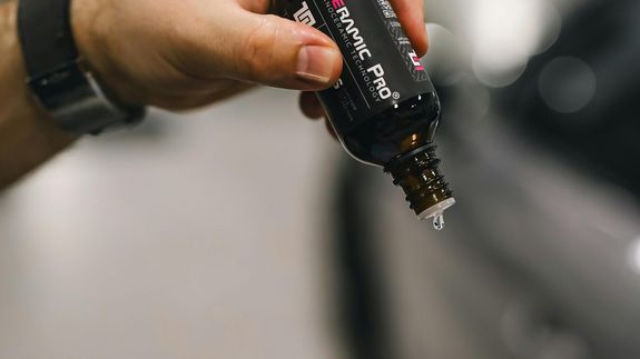 Close-up of a BMW convertible's tail light and emblem, showcasing luxury design.