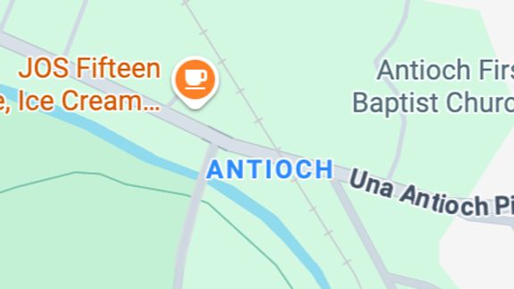 Two green garbage bins numbered 1 and 2 beside a white picket fence in Jönköping, Sweden.