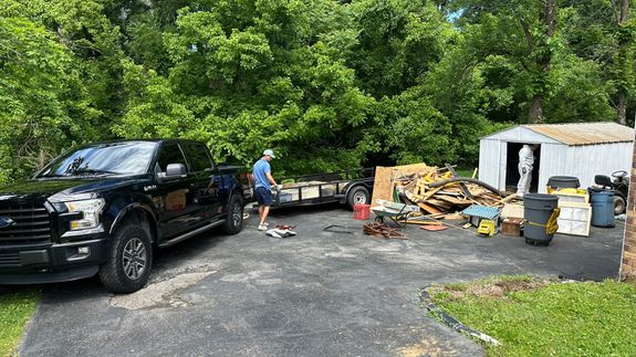 A vibrant urban scene featuring a garbage truck on a street lined with palm trees and people enjoying the promenade.
