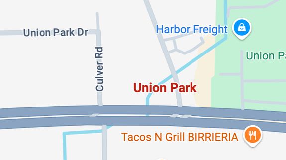 Worker applying a car wrap using a heat gun for precise adhesion.