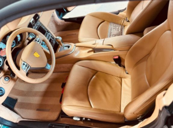 Sleek black luxury car parked in a modern, well-lit garage with a polished floor.